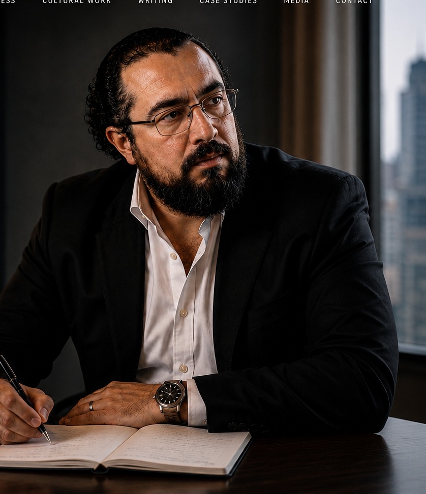 Portrait of Yossi Marchette seated at a desk, writing in a notebook